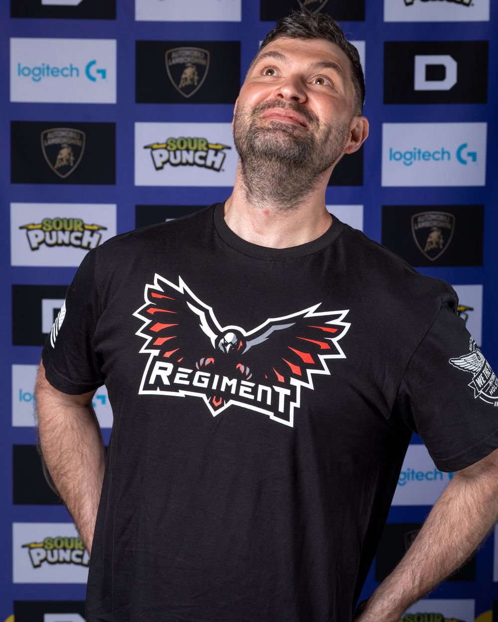 Smaw in a Regiment shirt, smiling, hand on hip